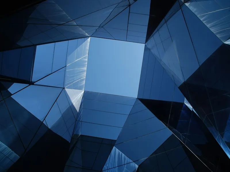 Low-angle view of a blue glass building facade